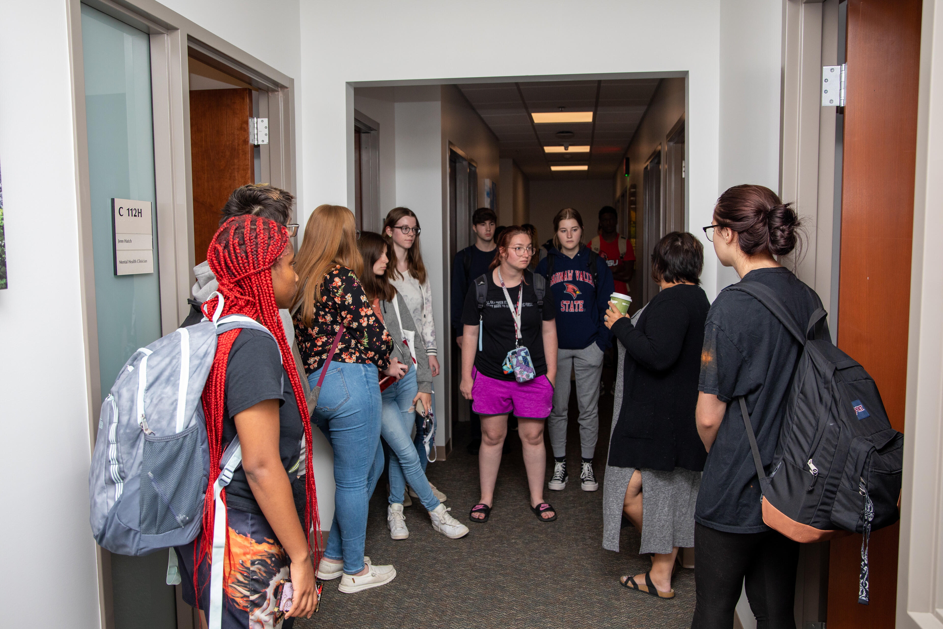 Group of college students standing outside of room